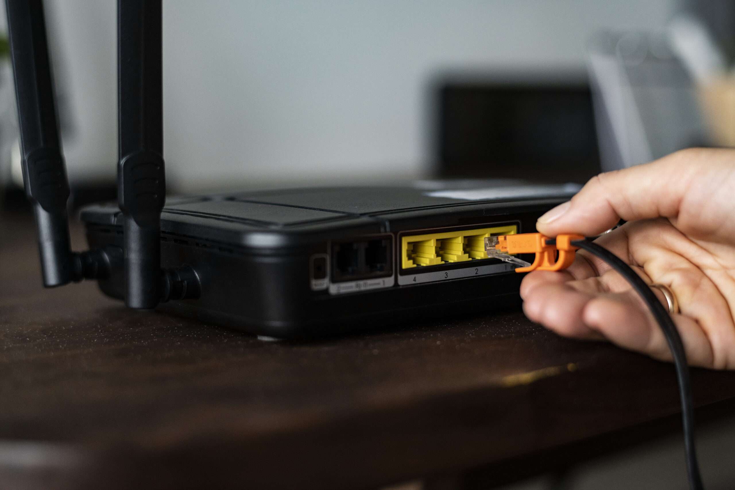 man plugging ethernet cable wireless router